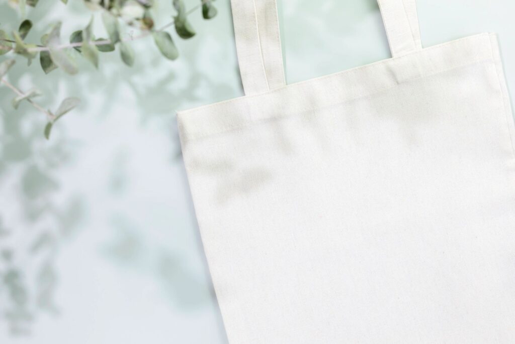 Mockup of white textile shopping bag on light blue background
