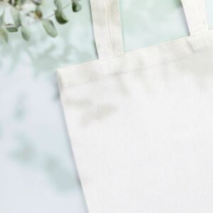 Mockup of white textile shopping bag on light blue background