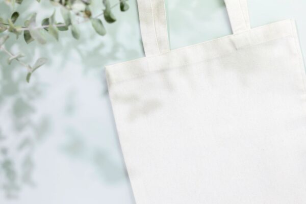 Mockup of white textile shopping bag on light blue background